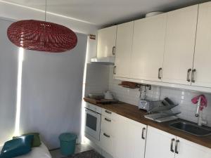 una piccola cucina con armadi bianchi e lavandino di Comporta Natura & Beach a Tróia