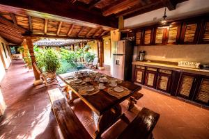 a dining room with a table and a kitchen at La Casa Amarilla in Mompos