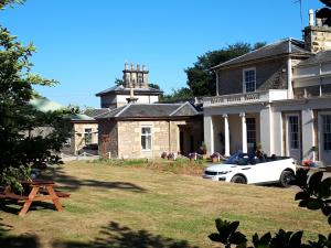 um carro branco estacionado em frente a uma casa em Elgin Self Catering Holiday Cottage em Elgin