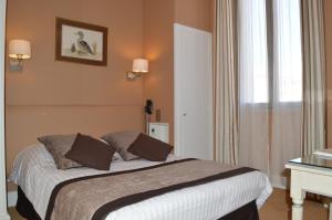 a bedroom with a bed and a table and a window at Hotel Splendid in Cannes