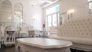 a living room with white chairs and a table at Hotel Melia Ponce in Ponce