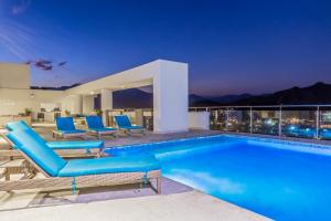 una piscina con sedie blu e una casa di Best Western Plus Santa Marta Hotel a Santa Marta