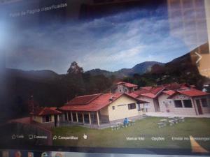 una foto de una casa con montañas en el fondo en Pousada Tia Lilía en Gonçalves