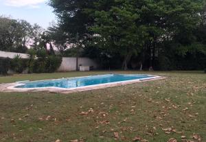 a small swimming pool in a yard with a grass field at Seven Gables in Port Elizabeth