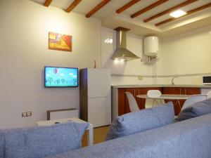 トレドにあるApartamento B con Garaje Privadoのキッチン、リビングルーム(壁にテレビ付)