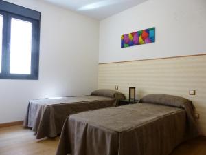 トレドにあるApartamento B con Garaje Privadoのベッド2台と窓が備わる客室です。