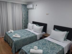Dos camas en una habitación de hotel con toallas. en Dzveli Batumi, en Batumi