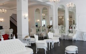 a room with white chairs and tables and mirrors at Hotel Melia Ponce in Ponce