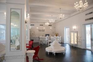 a white room with tables and chairs and chandeliers at Hotel Melia Ponce in Ponce