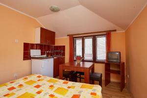 a bedroom with a bed and a table and a kitchen at Apartmani Malica in Soko Banja
