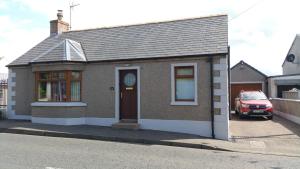 a small house on the side of a street at Dark Hedges Cottage in Ballycastle