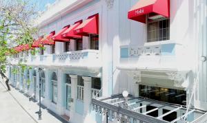 a white building with red awnings on a street at Hotel Melia Ponce in Ponce