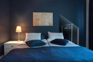 una habitación azul con una cama con dos almohadas en Boutique hotel Sawohouse, en Kuopio