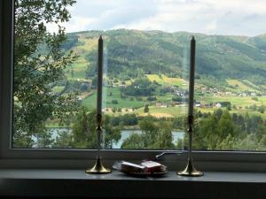 two candles sitting on a window sill with a view at Sagi 3 Exclusive Private Apartment in Hafslo