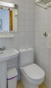Baño blanco con aseo y lavamanos en Hotel La Terraza, en Sanxenxo