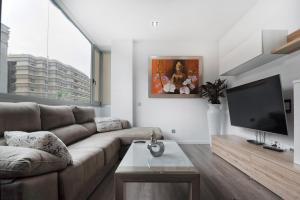 Il comprend un salon doté d'un canapé et d'une télévision à écran plat. dans l'établissement Apartamento de lujo Mesa y Lopez- Playa Las Canteras, à Las Palmas de Gran Canaria