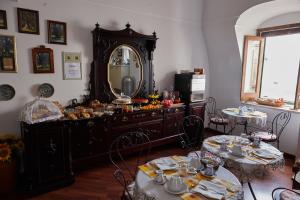 een kamer met een dressoir met een spiegel en 2 tafels bij Il Peschiciano in Peschici