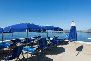 un gruppo di sedie e ombrelloni in spiaggia di Villino Emanuele a Santa Marinella