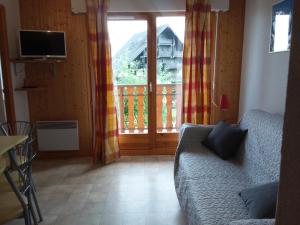 a living room with a couch and a large window at STUDIO entre ciel et Lac in Thollon