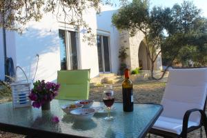 - une table avec une bouteille de vin et un verre dans l'établissement Villa Marikami, à Kamilárion