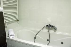 uma banheira branca com um chuveiro na casa de banho em Green Diamond em Zagreb