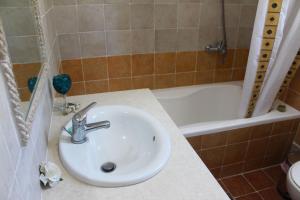 une salle de bains avec lavabo et baignoire dans l'établissement Villa Marikami, à Kamilárion 17 autres photos