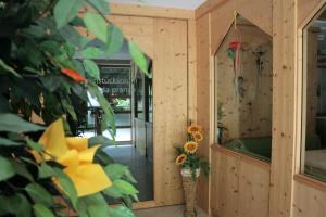 un edificio in legno con un vaso con fiori di Hotel Garni Angerer a Lutago