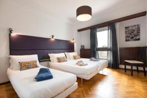 um quarto de hotel com duas camas e um sofá em LV Premier Apartments Clerigos-RE2 em Porto
