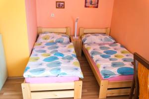 2 camas individuales en una habitación con paredes rosas en Ubytovanie u Jozefa, en Červený Kláštor