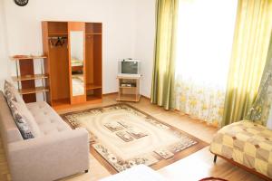 a living room with a couch and a tv at Evita Hotel in Dolinka