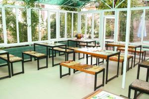 a restaurant with tables and chairs in a room with windows at Evita Hotel in Dolinka