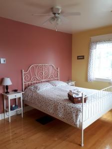 a bedroom with a bed and a ceiling fan at Dans les draps de Morphee in Campbellton