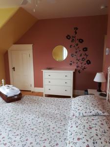 1 dormitorio con cama y espejo en la pared en Dans les draps de Morphee, en Campbellton
