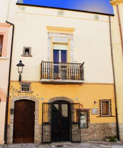 a building with a balcony and a door at La Luna nel Pozzo in Lesina