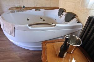 a white bath tub in a bathroom with a table at Casa Senderuela in Panzares