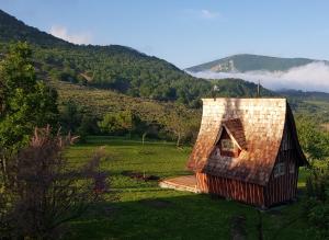 a small house in a field with mountains in the background at Chambre d'hôte insolite in Séderon