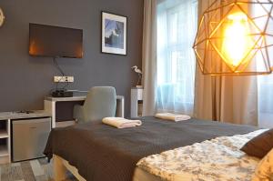 a bedroom with a bed and a desk and a television at Tawerna Rybaki Old Town in Gdańsk