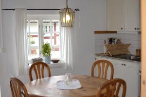 una cocina con una mesa de madera con sillas y una ventana en Kastanjegården på Stenshuvud en Kivik