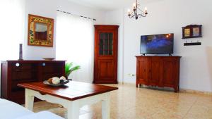 a living room with a table and a tv at Chocolate Rustic Apartment, in Tegueste in Tegueste