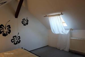 a bedroom with a bed and a white curtain at Rotkäppchen in Kratzeburg