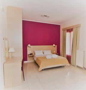1 dormitorio con cama y pared púrpura en Iridanos, en Antikyra