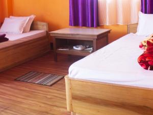 pokój z 2 łóżkami i szafką nocną między nimi w obiekcie Temi Sarika Homestay w mieście Damthang