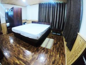 sypialnia z dużym łóżkiem i oknem w obiekcie Temi Sarika Homestay w mieście Damthang