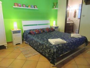 a bedroom with a bed and a green wall at Studio Apartment with garden and free parking in Giardini Naxos