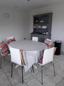 a dining room table with chairs and a table cloth at Foxholes Accommodation in Bristol