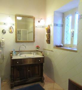 a bathroom with a sink and a mirror at Studio Apartment with garden and free parking in Giardini Naxos