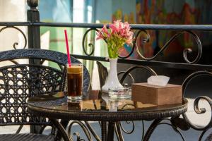 a table with a drink and a vase with a flower at Yerevan Boutique Hotel in Yerevan