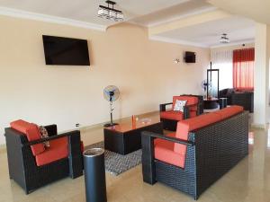 a living room with couches and a flat screen tv at Select Hôtel in Morondava