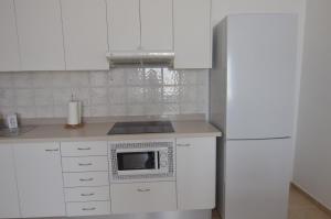 a kitchen with white cabinets and a white refrigerator at Armonía Beach 17 in Arinaga