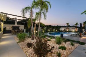 a backyard with a swimming pool and palm trees at Villa Thalia in Stalos